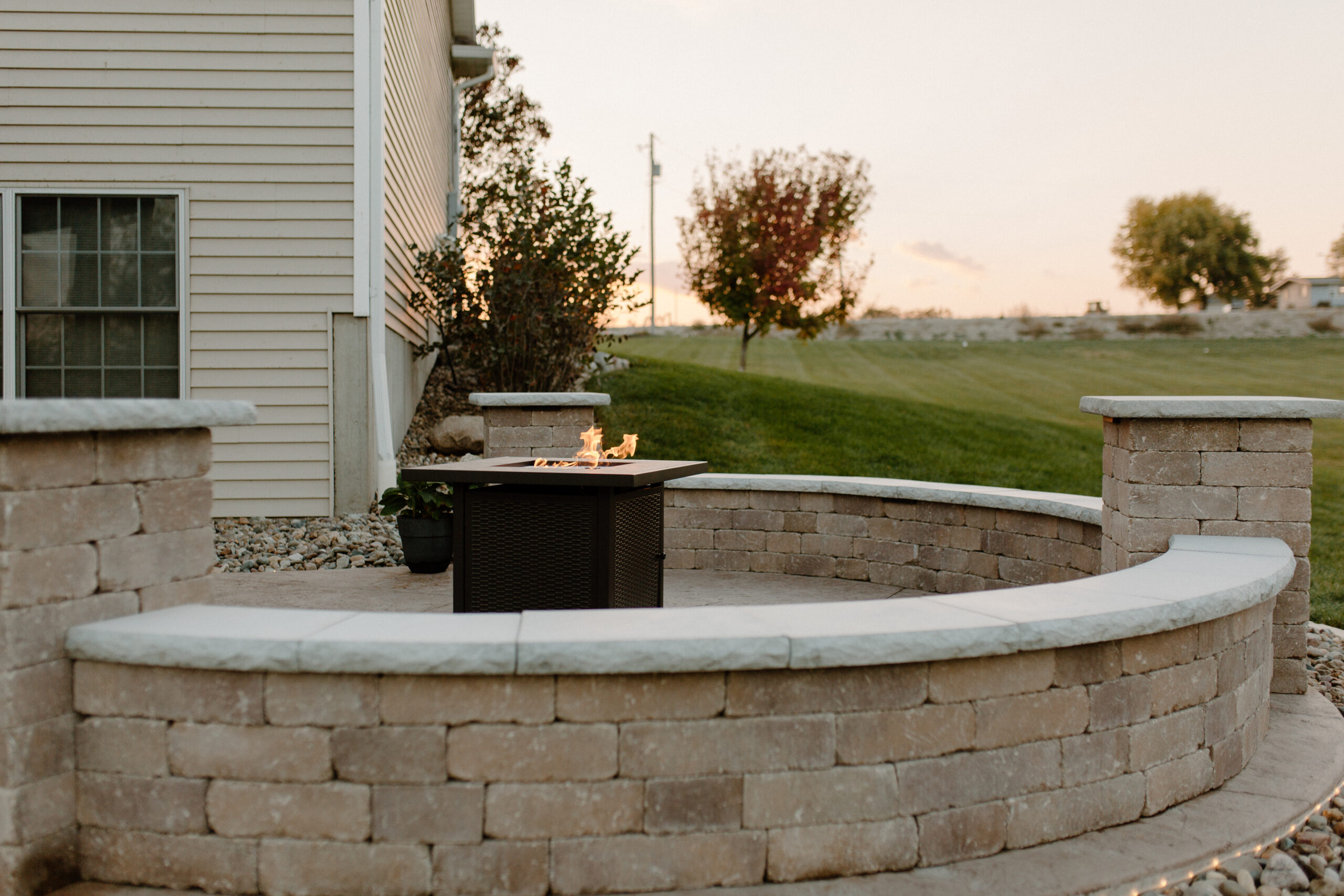 Fire going in a fire pit with a seating surround - Creative Nature Iowa