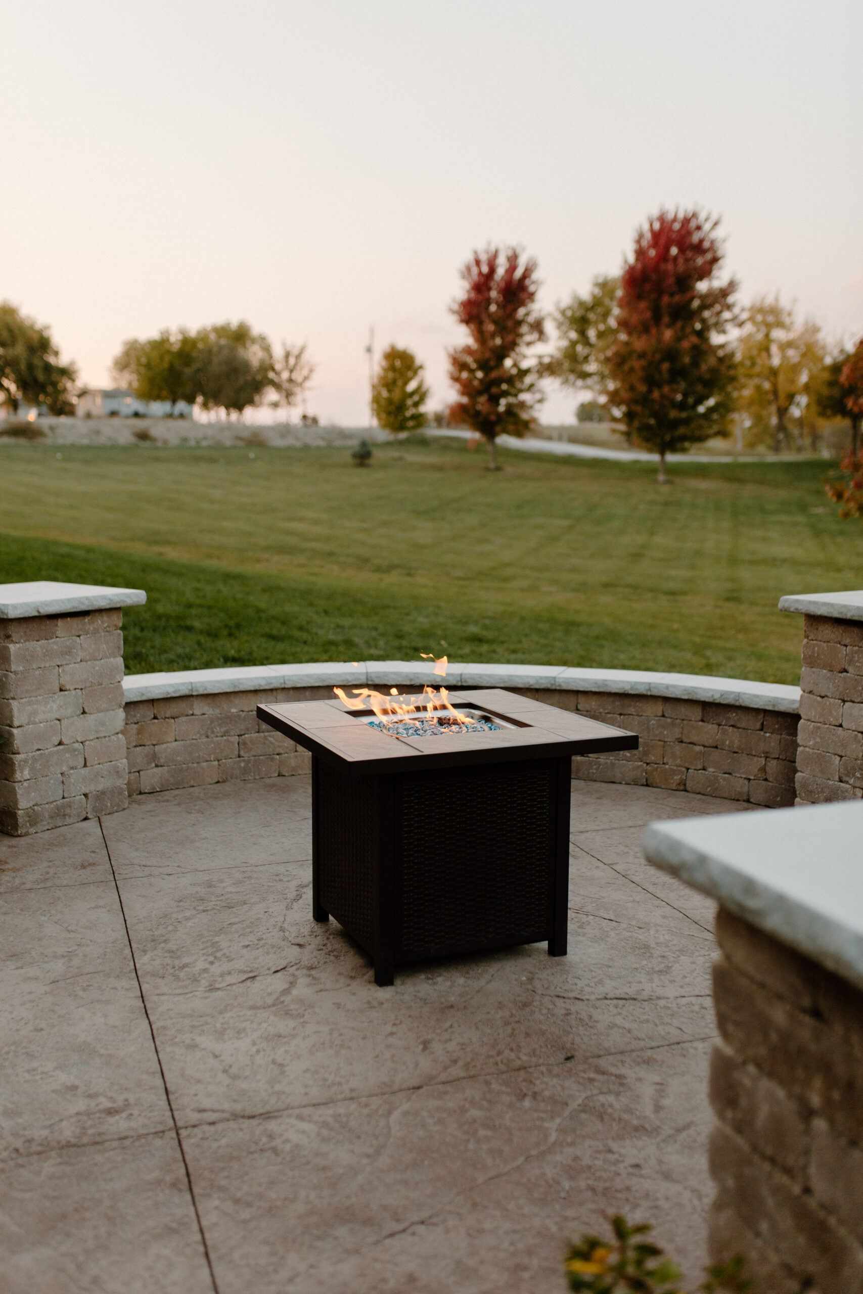 fire going in a firepit with a stone seating surround - Creative Nature Iowa