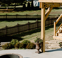 installation of a deck, firepit, poured patio, surrounding garden bed.